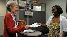 Image of a civilian helping another civilian in an office setting