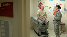 Image of an Airman talking to a male patient at the doctor's office
