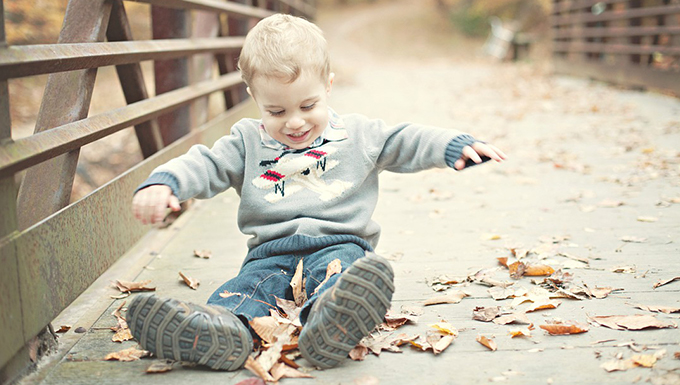 Image of a child sitting on a pedestrian bridge