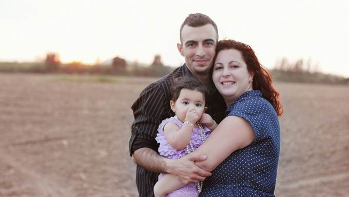 Image of a family standing outside posing for a picture