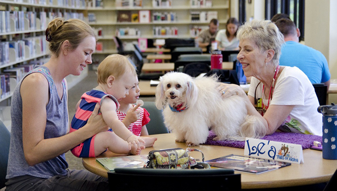 Image of a group of people at a library with a dog