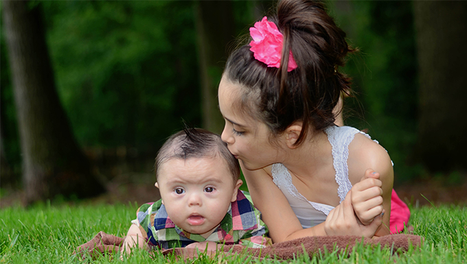 Image of a little girl kissing her little brother