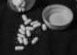 An open bottle of pills turned over with the pills coming out.